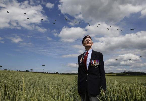 Le vétéran britannique de la campagne de Normandie, Fred Glover, 88 ans, pose tout en regardant le vol de 300 parachutistes de multi-nationalités à Ranville, France, le 5 Juin 2014 (source EUTERS/Chris Helgren)