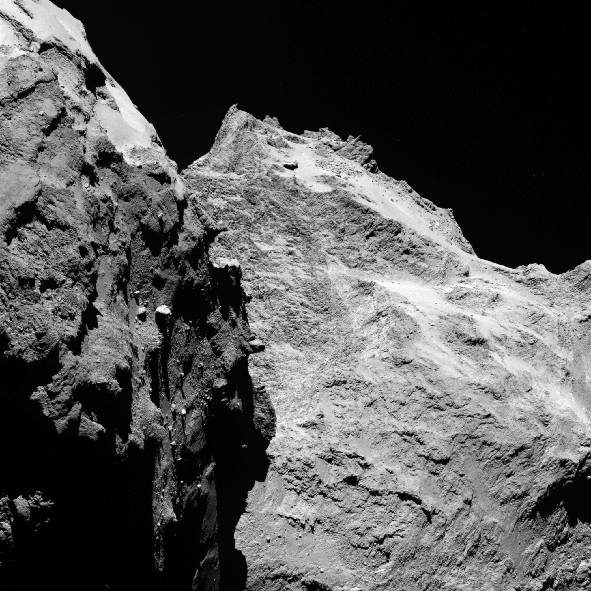 Des falaises abruptes et des rochers importants sont visibles sur cette image prise par la caméra OSIRIS le 5 Septembre 2014, lorsque Rosetta était à une distance de 62 kilomètres de la comète 67P / Churyumov-Gerasimenko. La partie gauche de l'image montre une vue de côté du «corps» de la comète, tandis que la droite est à l'arrière de sa «tête». Un pixel correspond à 1,1 mètres. (Crédit: ESA / Rosetta / MPS pour OSIRIS équipe MPS / UPD / LAM / IAA / SSO / INTA / UPM / DAPS / IDA)