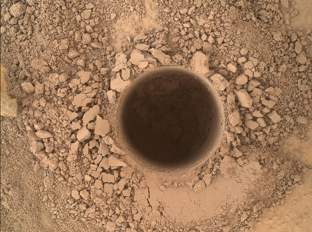 Cette image de la caméra Mahli du rover Curiosity montre le premier trou échantillon percé dans le mont Sharp. Le trou est de 1,6 centimètres de diamètre et d'environ 6,7 cm de profondeur, à une cible appelée "Confidence Hills" sur l'affleurement "Pahrump Hills" à la base de la montagne. C'est une image composée à partir de plusieurs images d'une position de 5 cm de la cible. Les images ont été prises le 24 septembre 2014, lors du 759e jour martien de Curiosity sur Mars. (Crédit image: NASA / JPL-Caltech / MSSS)