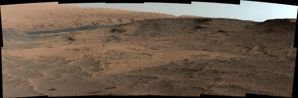 Cette vue de la caméra MastCam sur le rover Curiosity montre l'affleurement "Pahrump Hills" et le relief environnant vu d'une position à environ 20 mètres au nord-ouest de l'affleurement, le 17 septembre 2014, lors du 751e SOL. La scène comprend quatre régions distinctes: 1) des ondulations de sable au premier plan, du type de celles rencontrées dans le cratère Gale 2) la section Pahrump Hills de la formation Murray, où environ 18 mètres de la roche couches sont exposés 3) une crête plus sombre au loin vers la gauche 4) des pentes au nord-ouest du Mont Sharp à l'arrière-plan, où une transition brutale est apparente entre les buttes et les vallées dans la partie inférieure et les lits inclinés et sculptées dans la partie supérieure partie (Image Credit: NASA/JPL-Caltech/MSSS)