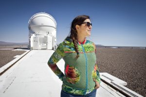 ESO astronomer Koraljka Music in front of one of the four auxiliary telescopes of the Very Large Telescope (VLT). On top of Cerro Paranal, Chile, the Very Large Telescope array (VLT) is the flagship facility for European ground-based astronomy. It is the worldÕs most advanced optical instrument, consisting of four unit telescopes with main mirrors of 8.2m diameter and four movable 1.8m diameter auxiliary telescopes.
