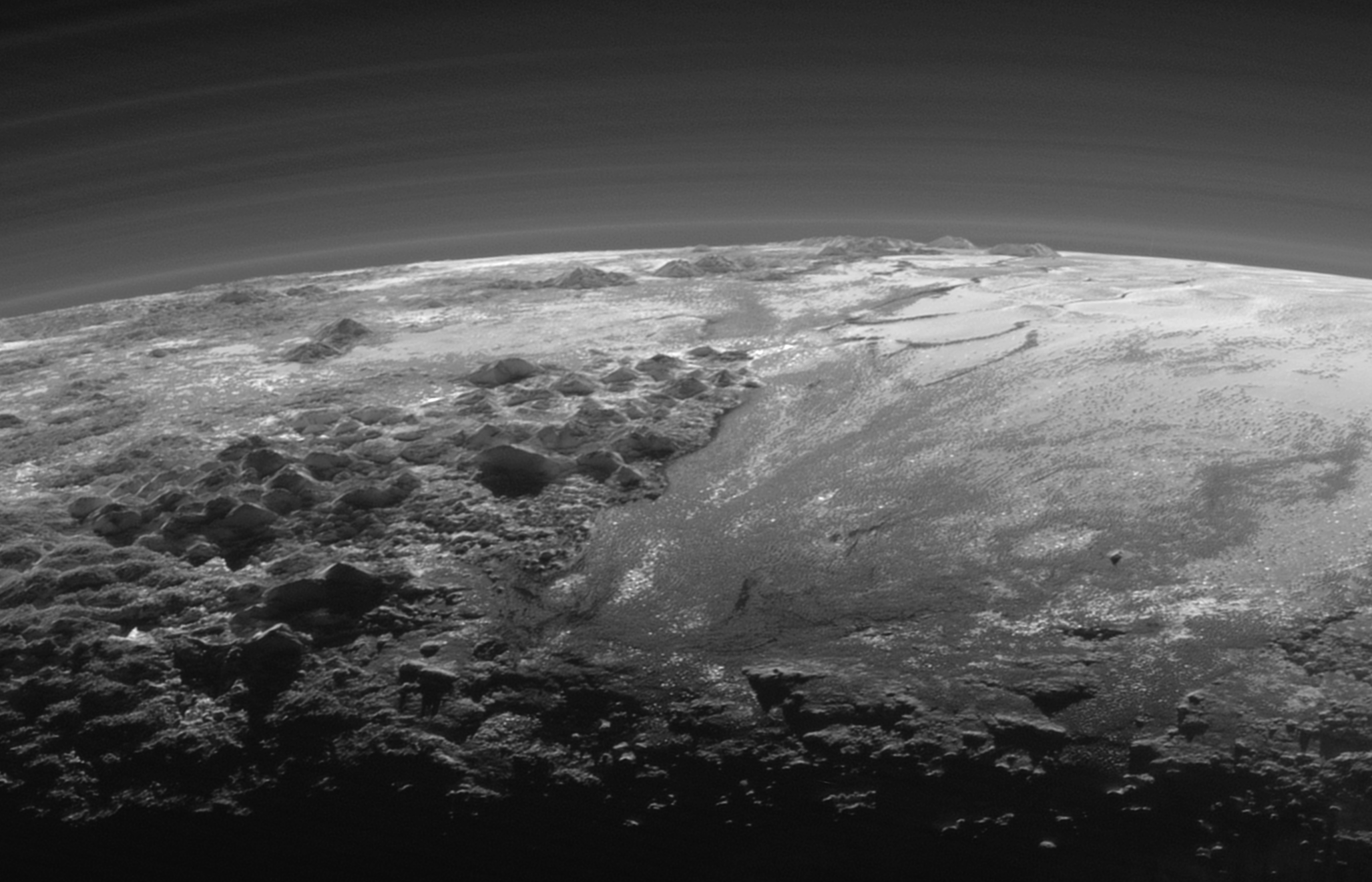 Image de Pluton prise par la sonde New Horizons le 14 juillet 2015 à une distance de 18 000 kilomètres. L'étendue lisse du Spoutnik Planum (à droite) est flanquée à l'ouest (à gauche) par des montagnes escarpées allant jusqu'à 3 500 mètres d'altitude. L'image couvre 380 kilomètres de large. (Crédits: NASA / JHUAPL / SwRI)