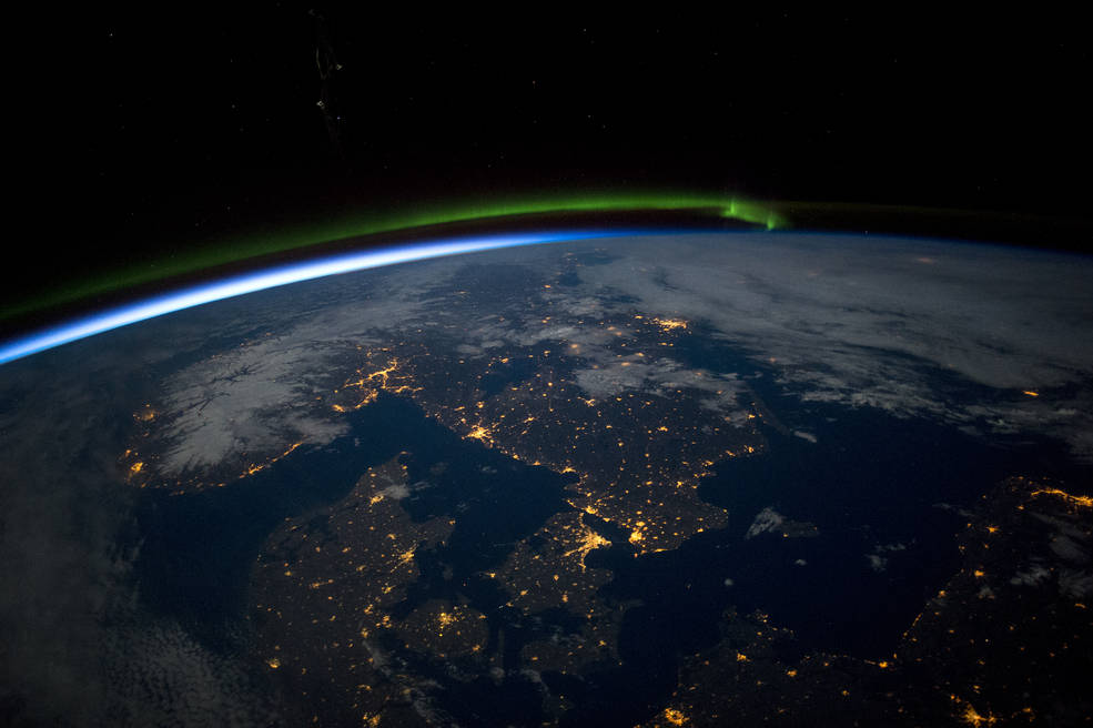 Le sud de la Scandinavie juste avant minuit sous une pleine lune, depuis l'ISS. On peut y voir une aurore boréale verte au nord, la noirceur de la mer Baltique (en bas à droite) (credit NASA).